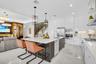 Modern kitchen featuring white glossy cabinetry, stainless steel appliances, and an expansive island with a white countertop