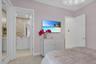 Plush carpeted bedroom featuring pale pink walls and a decorative ceiling fixture