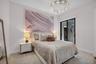 Spacious room featuring a decorative wall mural, contemporary chandelier, and soft carpeting