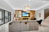 Spacious living area featuring polished tile flooring and recessed lighting