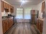 Kitchen featuring wood-finish flooring, wood cabinetry, a stainless steel refrigerator, and a stainless steel range