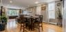 The spacious first-floor living and dining area features polished hardwood floors, modern recessed lighting, and clean neutral walls. A large round di