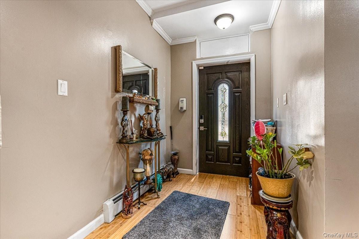 The entryway welcomes you with high ceilings, warm hardwood floors, and a gorgeous dark wood front door featuring an elegant glass insert. The wide fo
