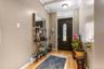 The entryway welcomes you with high ceilings, warm hardwood floors, and a gorgeous dark wood front door featuring an elegant glass insert. The wide fo