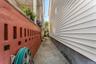 A concrete side alley connects the front of the property directly to the backyard for easy outdoor access. This straight, paved walkway is bordered by