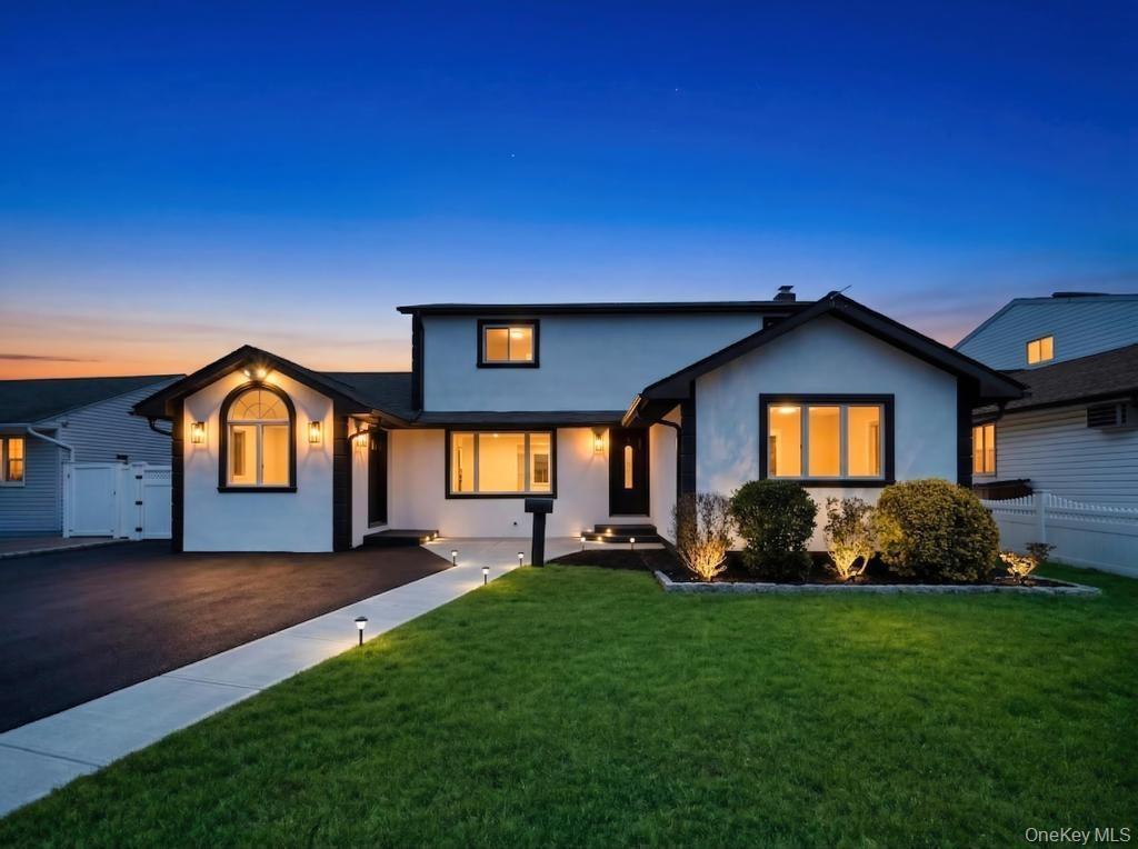 Modern-style exterior featuring a white facade with dark trim, an arched window, and multiple outdoor sconces