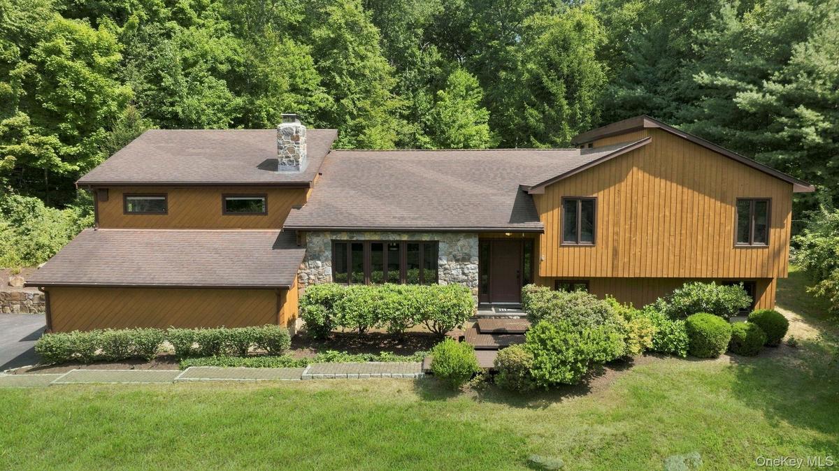Wood-finish siding with stone accents and a stone chimney
