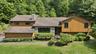Wood-finish siding with stone accents and a stone chimney