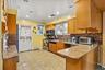 Kitchen featuring wood cabinetry, granite-finish countertops, tile backsplash, stainless steel appliances, and recessed lighting