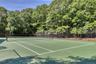 Private tennis court featuring a hard green surface and white court lines