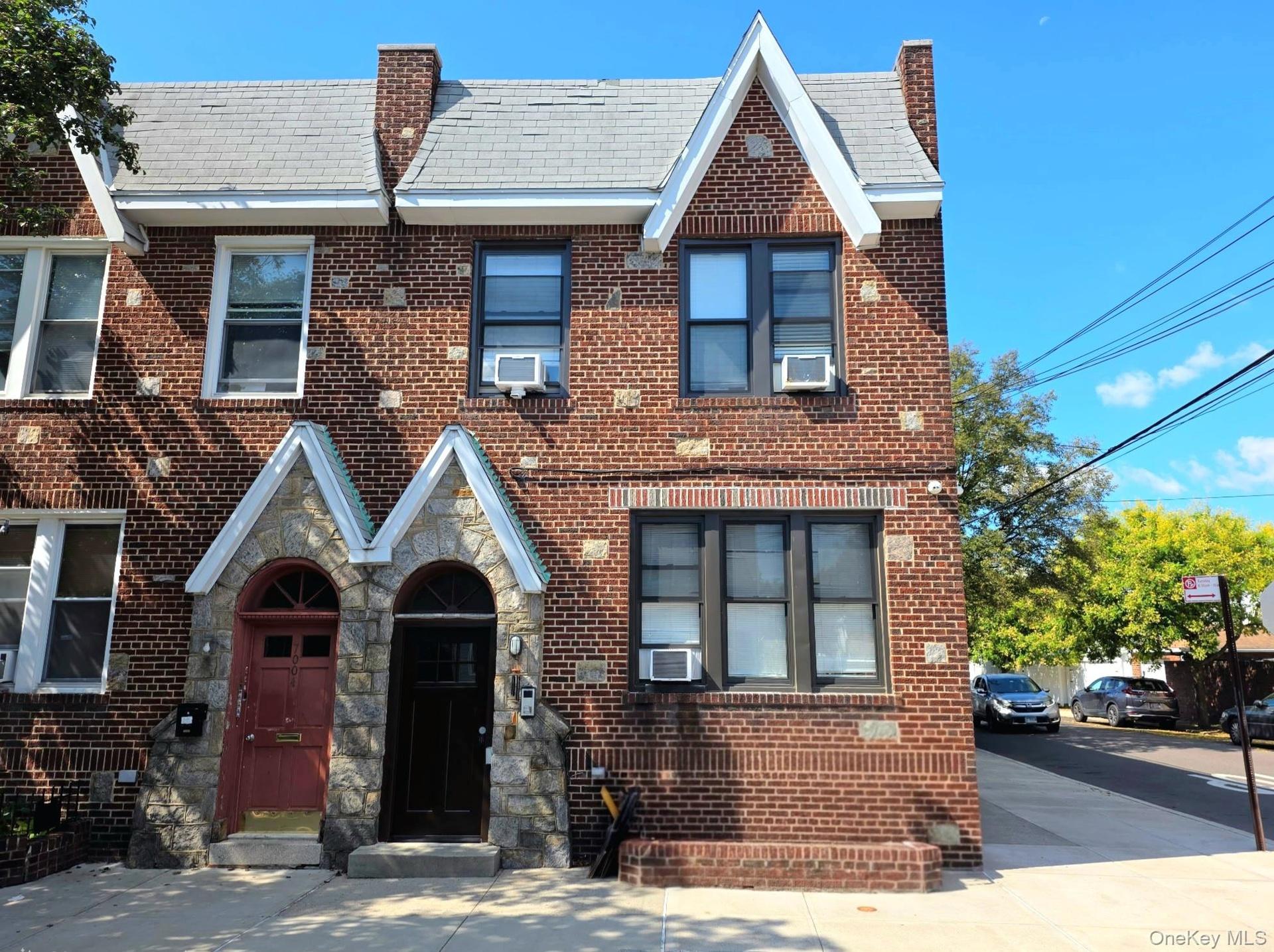 Brick facade building featuring a gabled roofline and stone entryway accents