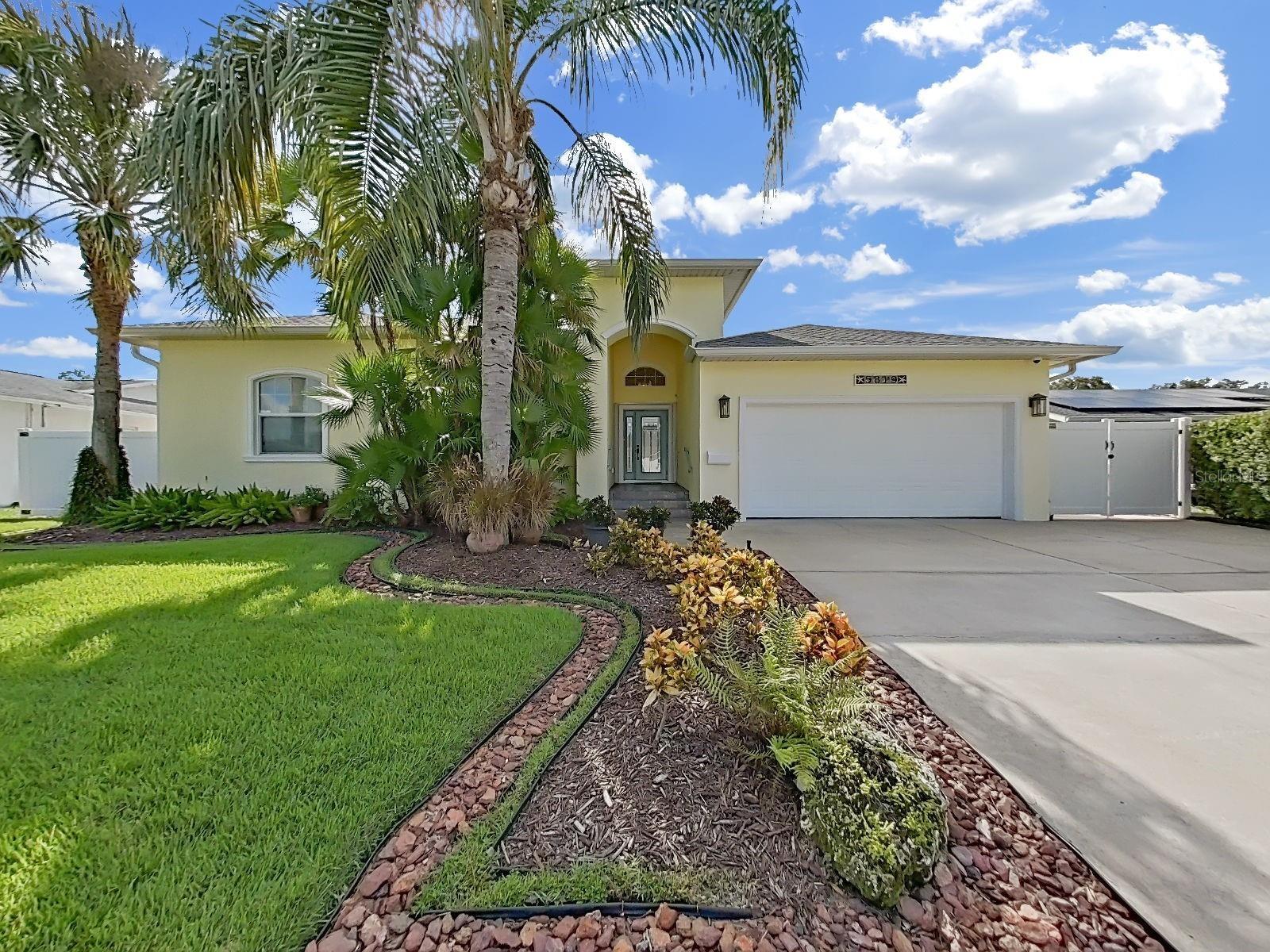 Meticulously cared for and beautifully landscaped with mature palm trees and garden beds. The large driveway and arched entryway welcome you home.