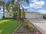 Meticulously cared for and beautifully landscaped with mature palm trees and garden beds. The large driveway and arched entryway welcome you home.
