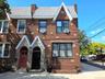 Brick facade building featuring a gabled roofline and stone entryway accents