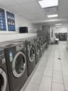 Shared laundry room featuring independent washer and dryer and light tile patterned floors