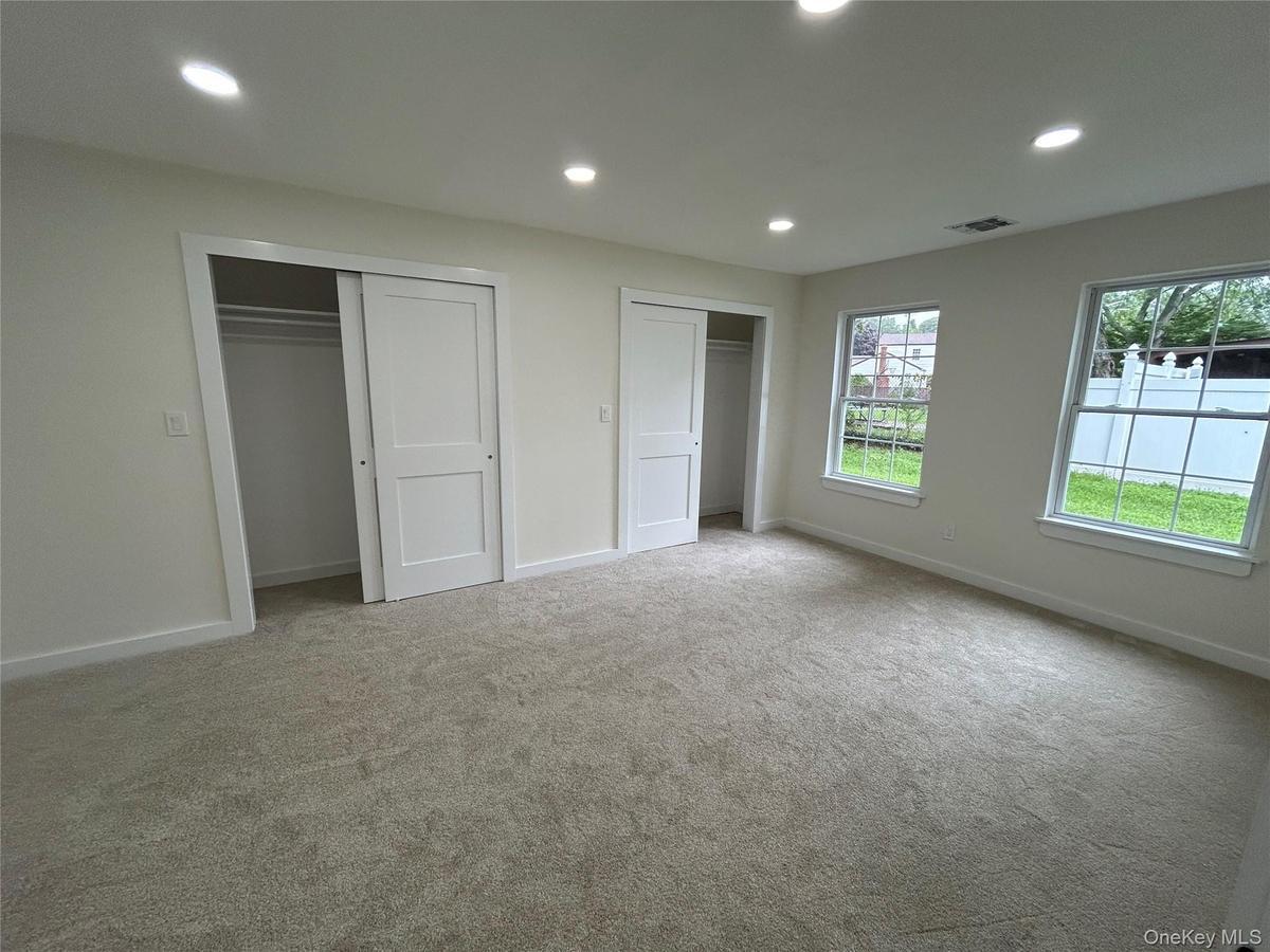 Bedroom with double closet and new carpeting