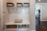 The drop area is located off of the kitchen and leads to the laundry room and the garage.