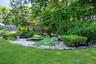 Koi pond with a three-level waterfall, full plumbing and filtration system, and a covered design complete with a dedicated viewing bench.