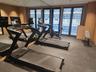 Fitness area featuring two treadmills, an exercise bike, a weight bench, and a rubberized flooring surface