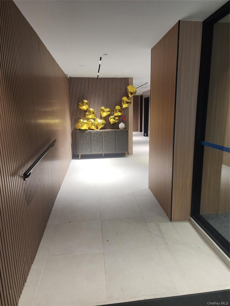Wood-finish slatted wall panels, recessed lighting, and large format floor tiles