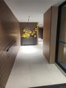 Wood-finish slatted wall panels, recessed lighting, and large format floor tiles
