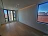 Recessed ceiling lighting, a coved lighting feature, wood-finish flooring, and large windows with black frames