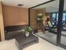 Wood-paneled wall, white ceiling, recessed lighting, white flooring, and glass wall
