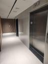 Modern elevator access with brushed metal doors and light-toned tile flooring