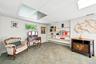 Recessed lighting within a drop ceiling, wall paneling, built-in shelving, carpeted flooring, and a window with exterior visibility