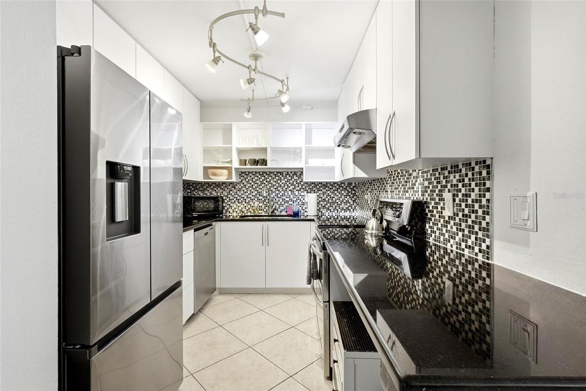 Kitchen - Washer and dryer plug ins available underneath counter across from fridge