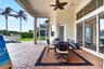 Expansive outdoor patio featuring brick pavers, a built-in pool, and a ceiling fan