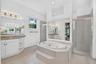 Dual vanity with granite-style countertop, white cabinetry, and undermount sinks