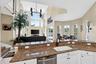Kitchen island featuring a white undermount sink, gooseneck faucet, and integrated dishwasher