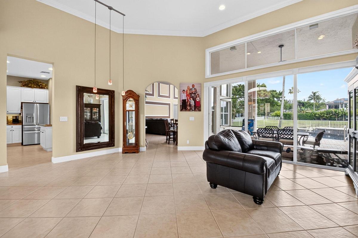 Expansive living area with vaulted ceilings, recessed lighting, and large format floor tiling