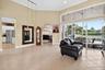 Expansive living area with vaulted ceilings, recessed lighting, and large format floor tiling