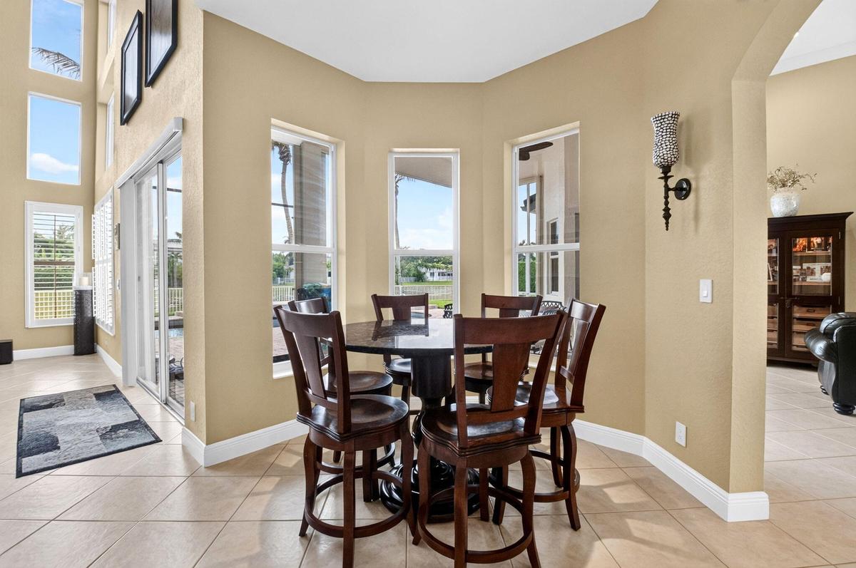 Bay window seating area, tile flooring, glass sliding doors, and a decorative wall sconce