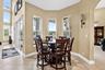 Bay window seating area, tile flooring, glass sliding doors, and a decorative wall sconce