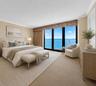 Virtually staged; residence is offered unfurnished. The primary bedroom frames direct Atlantic Ocean views and opens to the balcony.