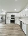 White cabinetry with brushed nickel hardware, stainless steel appliances, light-toned countertops, subway tile backsplash.