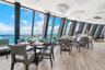 Dining tables line expansive windows overlooking the Atlantic Ocean in one of Tiara's restaurant spaces.
