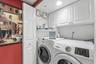 The interior laundry area includes a full-size washer and dryer with upper cabinetry for additional storage.