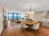 Virtually staged; residence is offered unfurnished. The open living and dining area is framed by direct Atlantic Ocean views, with the kitchen and bre