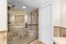 The primary bathroom combines a substantial vanity, tiled finishes and a glass-enclosed shower to create a comfortable, well-appointed en-suite retrea