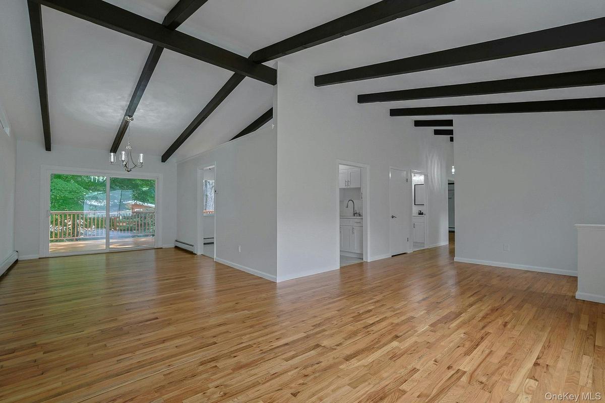 Living room looking into the dining room showing beamed cathedral ceiling