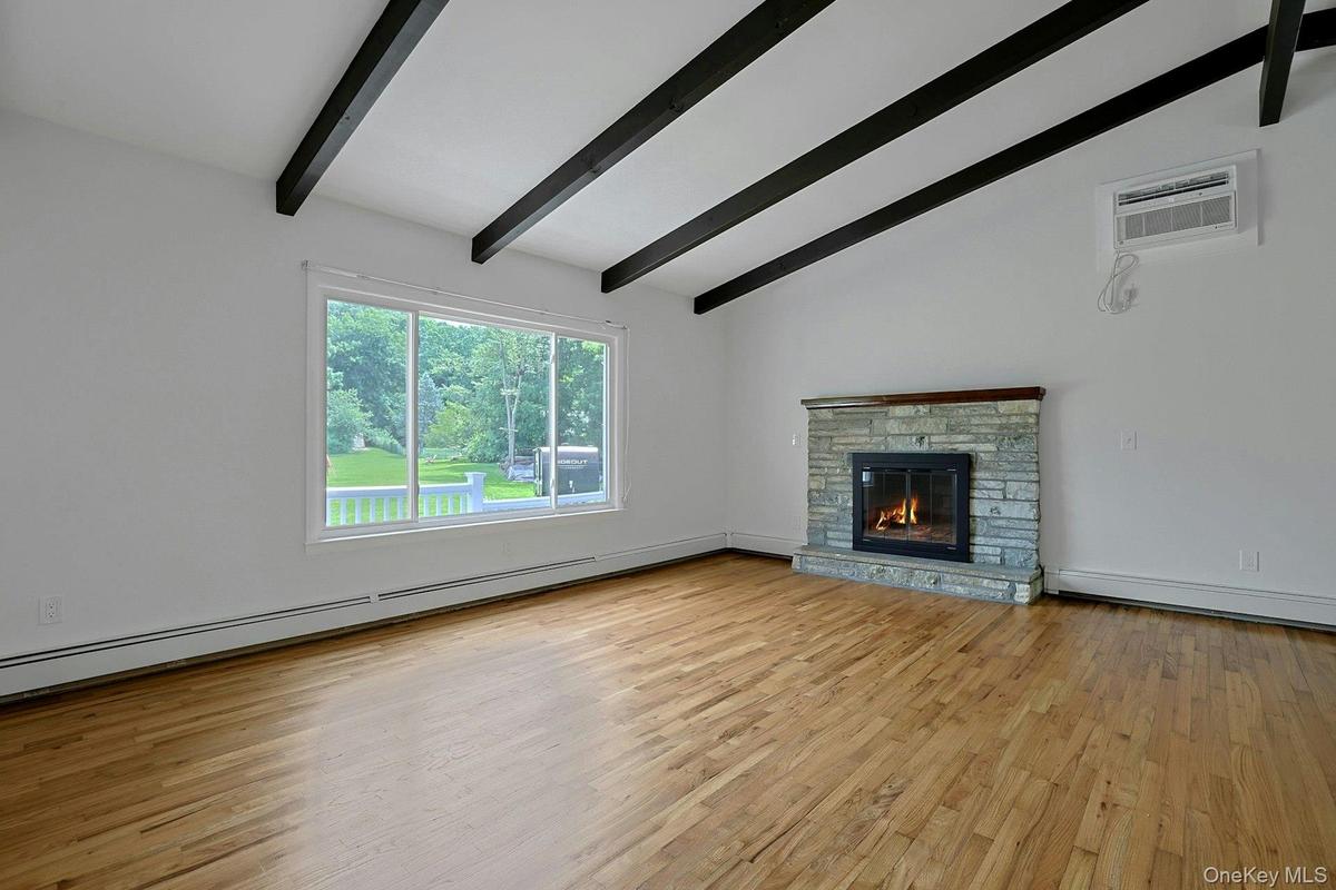 Another view of the living room featuring the large window for lots of natural light