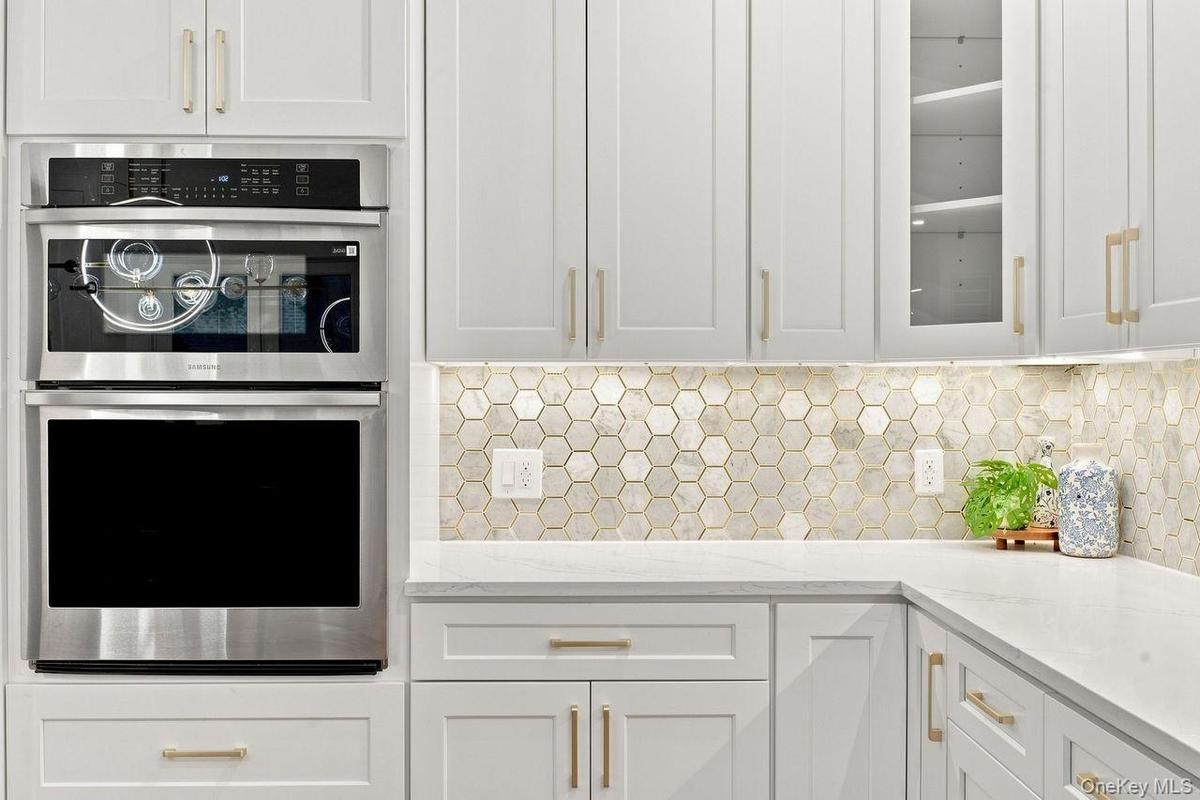 In wall oven and microwave with warming functionality and beautiful marble tile backsplash with gold metallic accents!