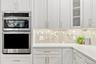 In wall oven and microwave with warming functionality and beautiful marble tile backsplash with gold metallic accents!