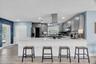 Large quartz peninsula provides additional prep space and casual seating while keeping the kitchen open to the living areas.