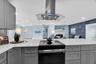 New stainless-steel appliances include a vented range hood and French-door refrigerator with an illuminated glass display panel.