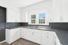 Kitchen featuring white cabinetry, dark countertops, and light wood-type flooring